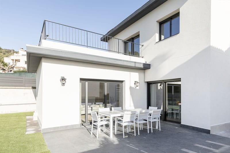 Fachada exterior de vivienda unifamiliar moderna con terraza y grandes ventanales en Viladecavalls, proyecto de Inteco Construcción.