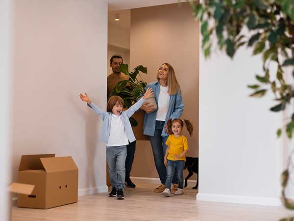 Familia entrando feliz a su nuevo hogar reformado por Inteco Construcción en Barcelona