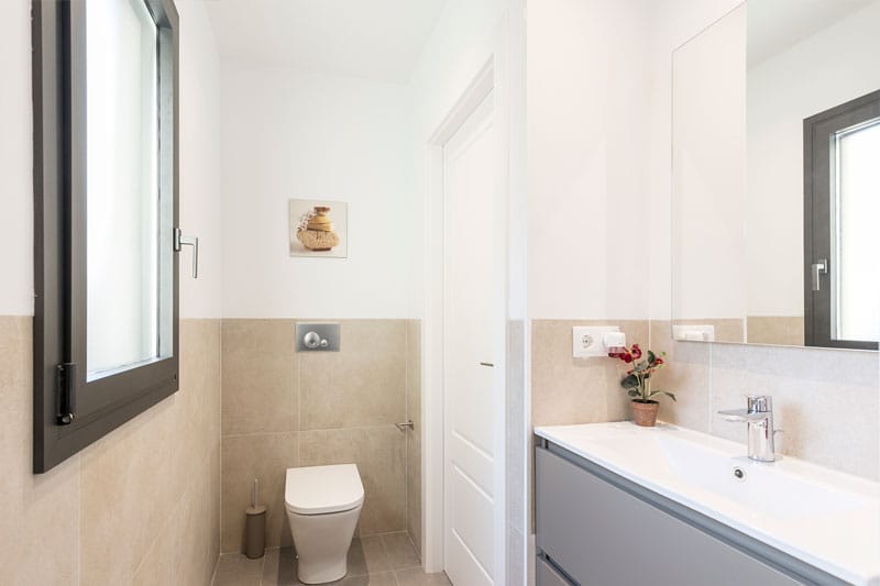 Baño secundario moderno con sanitarios suspendidos y mueble lavabo en vivienda de obra nueva en Viladecavalls