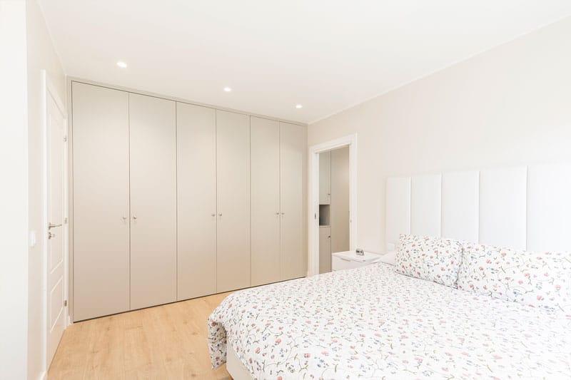 Dormitorio principal con armario empotrado de suelo a techo en vivienda unifamiliar de obra nueva en Viladecavalls, realizada por Inteco Construcción.