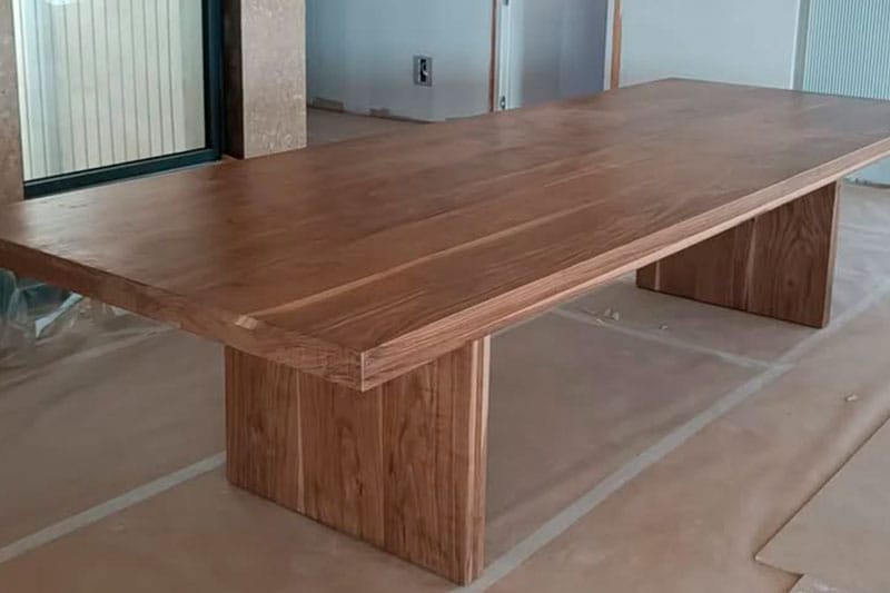 Mesa de comedor de madera maciza recién instalada en ático reformado en Passeig de la Bonanova, Barcelona.